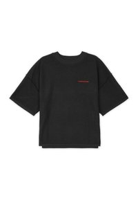 Svart oversized t-skjorte laget av myk bomull, med korte ermer, rund hals, og en kontrasterende rød logo på forsiden.