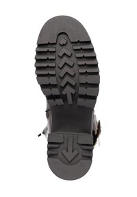 Suela de bota de goma negra con un patrón de banda de rodadura profundo, que presenta flechas y líneas horizontales para tracción; superficie texturizada y diseño sólido.