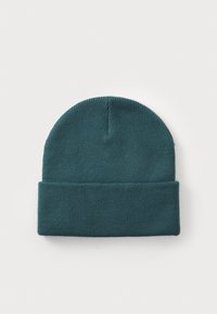 Gorro de malha em verde-azulado escuro, com uma textura macia, topo arredondado e um punho dobrado. Design simples, sem padrões ou adornos.