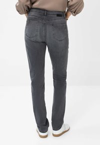 Grå denim jeans med lige pasform, som har to baglommer, diskrete syninger og et sort mærketag ved taljen.