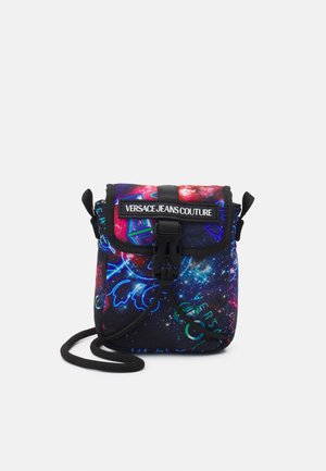 Petit sac bandoulière avec imprimé galaxie, bordure noire, fermeture avant à boucle et étiquette "Versace Jeans Couture" sur le rabat.