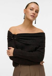 Off-shoulder svart stickad tröja med en texturerad finish, med en vriden detalj vid halslinningen och små metallicdetaljer.