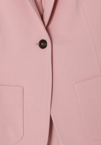 Světle růžový blazer s klasickým límcem, jedním hnědým knoflíkem a dvěma předními kapsami. Hladká tkanina s přiléhavým střihem.