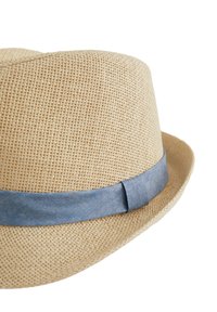 Bežna slamnata kapa s mekom, tkanom teksturom i svijetloplavom platnenom trakom oko osnove. Kapa ima klasičan, blago zakrivljen rub.