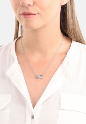Collana infinito in argento con un design ad anello, impreziosita da piccole gemme trasparenti incastonate, appesa a una delicata catena.