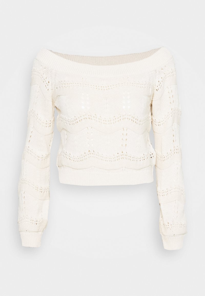 Suéter de punto de ganchillo sin hombros en color crema, con un patrón ondulado, puños acanalados y una silueta corta. Tejido suave y texturizado.