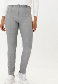 Šedé slim-fit kalhoty s texturovanou látkou, s vysokým pasem, bočními švy a předním zapínáním na knoflík, doplněné bílými teniskami.