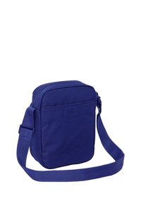 Niebieska torba na ramię o prostokątnym kształcie, z zamknięciem na zamek i regulowanym paskiem. Gładka tekstura bez widocznych wzorów czy elementów metalowych.