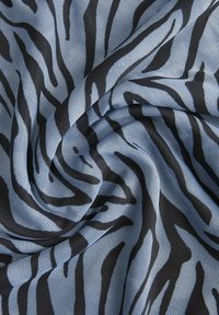 Tela azul con un patrón de malla texturizada que presenta rayas de cebra negras, creando un diseño contrastante con una superficie suave y flexible.