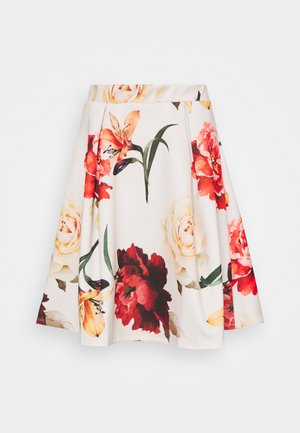 Hvid A-formet nederdel med stort rødt, orange og cremefarvet blomsterprint og grønne blade, med plisseringer og en tætsiddende talje.