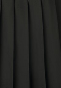 Tessuto plissettato nero con una texture liscia, caratterizzato da pieghe verticali distribuite uniformemente, creando un aspetto strutturato ed elegante.