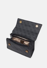 Mustikkakuosisella käsilaukulla, jossa on kultaiset yksityiskohdat. Avoin malli paljastaa vaaleanbeige sisätilan ja brändilogon. Varustettu magneettisoljilla.