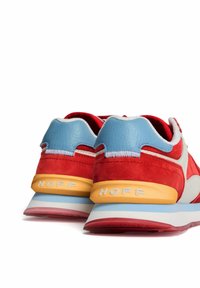 Zapatillas de ante y cuero rojas con acentos azules, que cuentan con una pestaña en el talón amarilla y la marca blanca "HOFF" en el lateral y la suela.