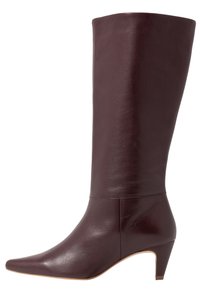 Bottes en cuir bordeaux montant jusqu'au genou, avec un bout pointu et un talon de hauteur moyenne. Texture lisse et design minimaliste sans aucune quincaillerie visible.