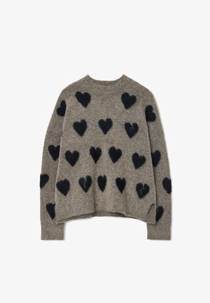 Pull gris à coupe décontractée, orné de motifs en forme de cœur noirs en matière pelucheuse sur le devant et d'un design col rond facile à porter.