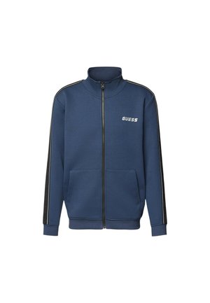 Felpa con zip di colore blu marina, presenta un colletto alto, due tasche frontali, logo bianco sul petto e strisce nere sui lati. Texture del tessuto morbida.