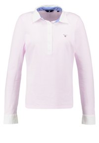 Długosleeve polo w miękkim różowym bawełnie, z białym kołnierzykiem i mankietami oraz jasnoniebieskim wewnętrznym kołnierzem. Małe logo na klatce piersiowej.