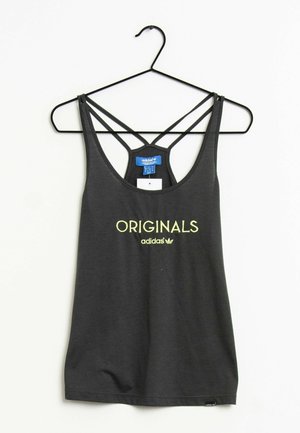 Black Adidas Originals tank top with thin crisscross straps hanging on a black wire hanger against white background.