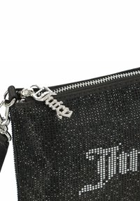 Črna torbica iz rhinestones z zlatim zadrgo, čarom s besedo "Juicy" in gladko teksturirano obliko.