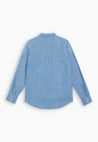 Chemise en denim bleu clair à manches longues, vue de dos, avec empiècement pointu et poignets boutonnés sur fond blanc.