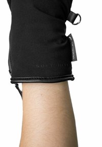 Black softshell glove with leather accents, form-fitting design, and textured finish. Features an adjustable strap and branding detail.