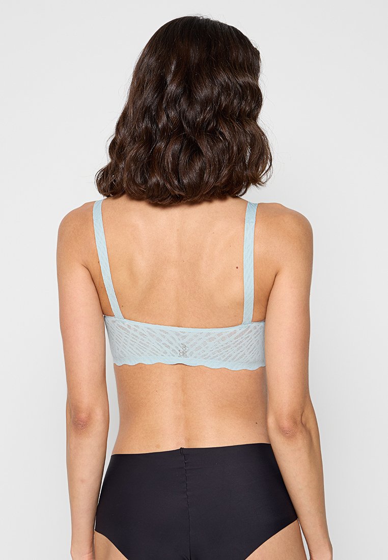 Hellblaue Spitzen-Bralette mit verstellbaren Trägern, gewellten Kanten und einem strukturierten Muster. Rückansicht zeigt ein glattes Design ohne Polsterung.