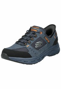Skechers Relaxed Fit jalatsid tumesinise ja musta värvusega, millel on võrkkangas ja seemisnahast paneelid, mäluvaht polsterdus ja oranžid aksessuaarid; tekstureeritud kummist tald.