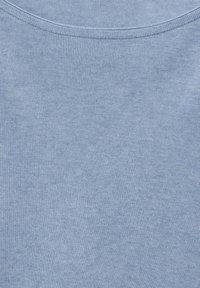 Vaaleansininen ribattua kangasta, jossa on pehmeä tekstuuri ja leveä avara kaula-aukko. Kangas näyttää joustavalta ja sileältä, sopii hyvin arkikäyttöön.