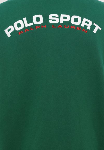 Zelené bavlněné tričko s velkým bílým a červeným nápisem "POLO SPORT" a "RALPH LAUREN" pod ním v kontrastní barvě. Měkká textura.