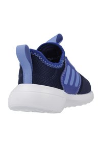 Zapatilla deportiva azul marino con parte superior de malla texturizada, talón reforzado y suela de goma blanca. Presenta dos rayas azul claro y una tira de agarre.