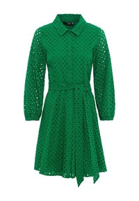 Grön klänning med krage, långa ärmar och knytmidja. Tillverkad av en strukturerad tyg med utskurna cirkulära mönster överallt.