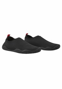 Fekete slip-on cipők rugalmas anyagból, textúrált gumi talppal és piros díszítéssel a sarkán. Kényelemre és könnyű felvételre tervezték.
