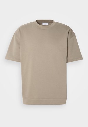 Khaki oversized t-shirt gemaakt van zacht materiaal, met een ronde halslijn, korte mouwen en een rechte zoom met minimale stikseldetails.