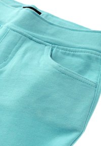 Hellblau Baumwoll-Jogginghosen mit weicher Textur, ausgestattet mit einem elastischen Bund und einer kleinen Seitentasche, sauber genäht mit verstärkten Nähten.