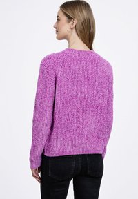 Fioletowy sweter z prążkowanym wzorem, z długimi rękawami i okrągłym dekoltem. Widok z tyłu pokazuje teksturowany splot i lekko luźny krój.