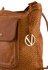 Brown leather handbag with woven texture, featuring a front pocket, rounded metal hardware, and a branded charm.