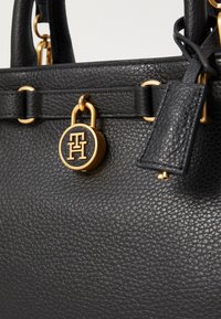 Geantă de umăr din piele neagră cu finisaj texturat, accesorii din aur și un charm cu logo rotund. Dispune de mânere duble și o etichetă detașabilă.