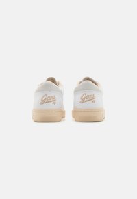 Weiße Leder-Sneaker mit beiger Gummisohle, weichem Innenfutter und dezentem "Gant"-Branding in Kursivschrift an der Ferse.