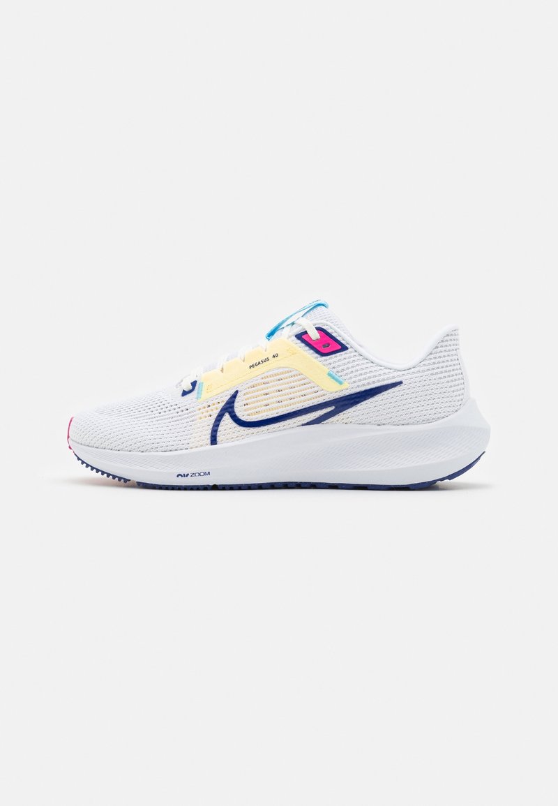Chaussure de course Nike blanche avec logo bleu marine, empeigne en mesh, maintien des lacets jaune, accents bleus et roses, et semelle rembourrée vue de profil.
