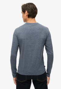 Langarm t-shirt in gemêleerd donkerblauwe stof, ronde halslijn, getailleerd silhouet, met een gladde textuur en een subtiel gebogen zoom.