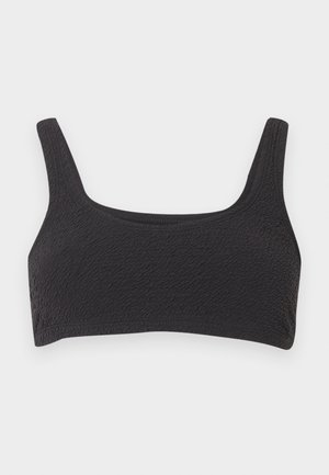 Fekete texturált anyagból készült sportmelltartó széles vállpántokkal és négyzet alakú nyakkivágással, világos háttéren laposan elhelyezve.