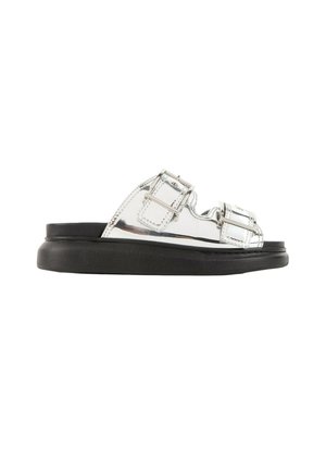 Sandalia tipo mule con punta abierta, dos correas ajustables con hebillas plateadas y una suela gruesa negra.