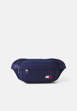 Banane bleu marine en tissu résistant. Comprend un compartiment principal zippé, un patch logo et une sangle ajustable avec branding.