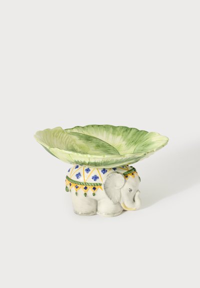 Pièce décorative en céramique avec un bol vert en forme de feuille sur une figurine d'éléphant blanche ornée de motifs bleus et jaunes.