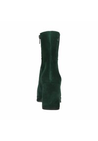 Groene suède enkellaars met een vierkante blokhak, ritssluiting aan de zijkant en een gladde textuur, die een elegante, op maat gemaakte silhoeët laat zien.