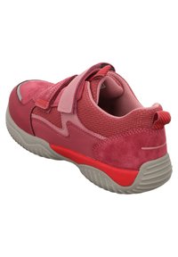 Roter und rosa Sportschuh aus Wildleder und Mesh-Materialien, mit verstellbarem Riemen, strukturiierter Sohle und kontrastierenden grauen Akzenten.