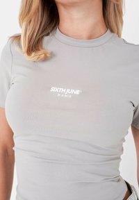 Grijs t-shirt met korte mouwen, gemaakt van zachte stof, met een ronde hals en geborduurd logo "SIXTH JUNE PARIS" op de voorkant.