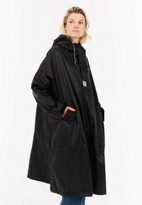 Zwarte waterdichte poncho met een capuchon, voorzien van een voorzak, trekkoorden en een losse snit. Soepele textuur en licht gewicht ontwerp.