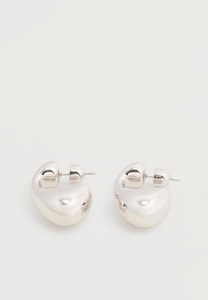 Ζευγάρι από λαμπερά ασημένια μεγάλα σκουλαρίκια κρίκους με κούμπωμα πίσω, σε απλό λευκό φόντο.