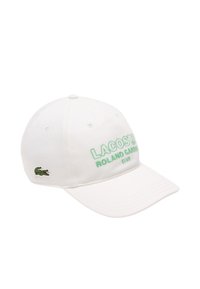 Gorra de béisbol blanca con el texto bordado en verde "LACOSTE ROLAND GARROS CLUB" y el logo del cocodrilo en verde. Elaborada en algodón, con visera curva.